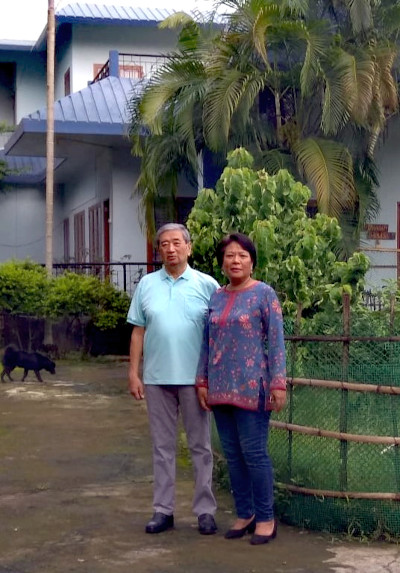 John and Shanti in front of their meadow bungalow.